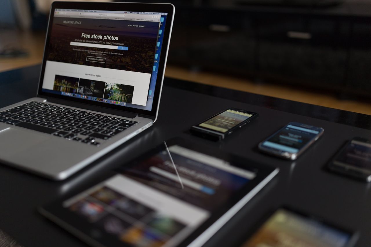 Un espace de travail moderne mettant en scène un ordinateur portable, une tablette et des smartphones, idéal pour un usage technologique et en freelance.